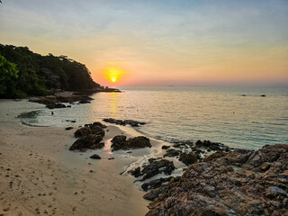 Breathtaking sunset over Koh Munnork Island in Rayong, Thailand enhances tranquil beach atmosphere