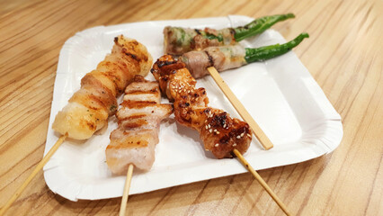 Delicious roasted cuisine seafood, BBQ food crispy shrimps and Bacon pork meat garlic and sea salt sauce, Fried cabbage vegetable okra, Crispy grilled squid and chicken wings, traditional Japanese 