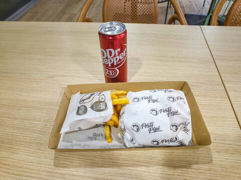 Budapest, Hungary - December 16, 2024: Pesti Pipi menu with Sajtos Baconos Pipi (Cheese Bacon Pipi) burger, french fries and Dr. Pepper.