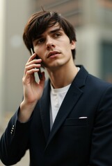 Stylish Young Professional Talking on Phone Outdoors in Formal Attire.