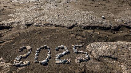2025 Written with Stones on Sandy Beach by the Sea