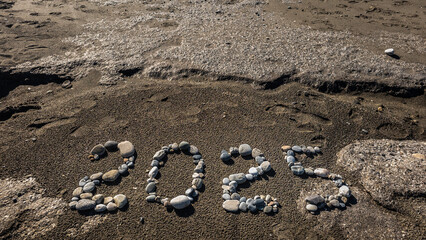 2025 Written with Stones on Sandy Beach by the Sea