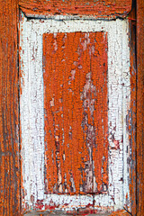 Texture of an old wooden surface with cracked red paint. close up