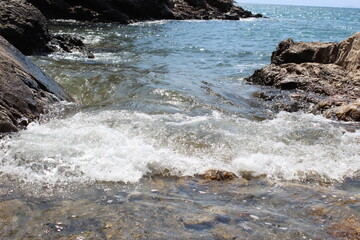 Tranquil nature scene with a sparkling river flowing through a lush forest, mountains in the background, and the sun casting golden light on the sandy beach, blending the beauty of earth, water, sun