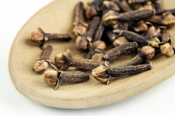 Cloves and wooden spoon on white  background
