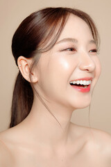 Naklejka premium Young Asian beauty woman pulled back hair with korean makeup style on face and perfect skin on isolated beige background. Facial treatment, Cosmetology, plastic surgery.