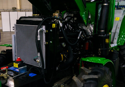 A close-up view of a modern tractor with the hood open, showcasing the powerful engine and intricate mechanics.