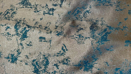 Detailed view of a textured fabric featuring shimmering gold and teal patterns in an abstract arrangement, perfect for showcasing luxury, elegance, and high-end textile design.