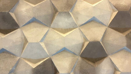 Close-up view of a geometric, three-dimensional textured surface with metallic gold and gray tones,...