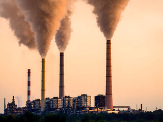Industrial power plant emitting smoke and steam against a soft, peach-colored sunset sky. Concept of air pollution, fossil fuels, climate change, and environmental impact.