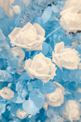 Infrared photography, a composition of flowers, primarily roses, in shades of blue and white