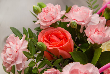 Pink carnations and roses on a white fabric background.