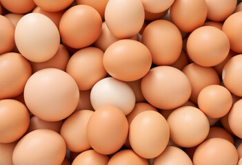 Closeup of various chicken eggs, some brown and some white, in a pile