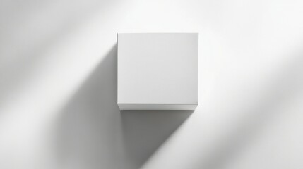 Obraz premium A single white square box with a seamless lid, photographed with a soft shadow on a clean and modern white background.