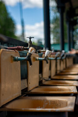 Water taps in the washbasins of a children's summer camp. Old faucets in washstands. Cranes in public washbasin for hygiene in the street.
