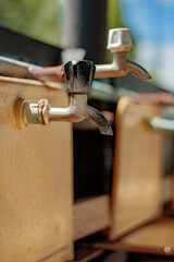 Water taps in the washbasins of a children's summer camp. Old faucets in washstands. Cranes in public washbasin for hygiene in the street.