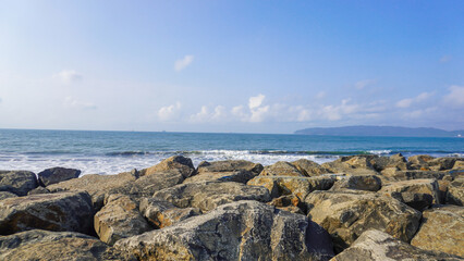 Rocks in the sea on blue sky background