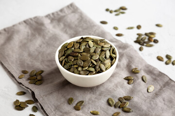 Healthy Raw Organic Pumpkin Pepita Seeds in a Bowl, side view.
