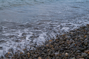 Water sea beach. Wave ocean blue. Stone texture reflection sun. Surface coast pebbles. 