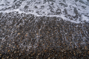 Water sea beach. Wave ocean blue. Stone texture reflection sun. Surface coast pebbles. 
