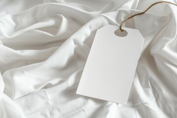 Blank white tag on crumpled white fabric. (1)