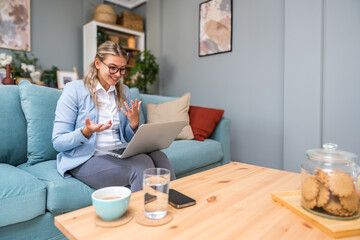 Young confident business woman working at home office on laptop computer, with formal wear and...
