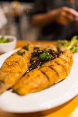 Fried sea bass with fish sauce. Close up