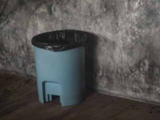 Trash can on the house floor. Plastic dustbin with garbage bag.