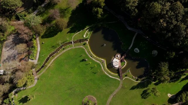 Aerial - golf course with landscaped greenery, a pond, and walking paths.