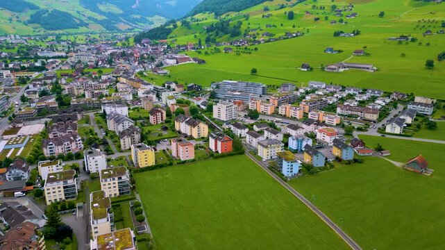 4K Drone Video of Train Passing Through a Village at the base of Stanserhorn Mountain in Stans, Switzerland