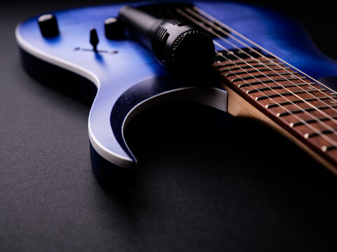 Microphone and electric guitar on a dark background.