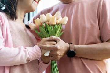 Senior Couple Celebrating Valentine's Day with Flowers and Love at Home in a Cozy and Warm Setting