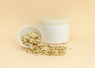 white cosmetic jar and oatmeal spilled from white cup on light background, template, design mockup