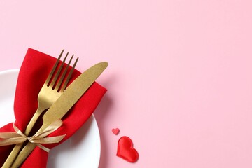 Valentine's Day concept. Top view photo with plate, cutlery and confetti on color background with empty space