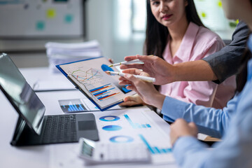 A group of people are looking at a graph on a table