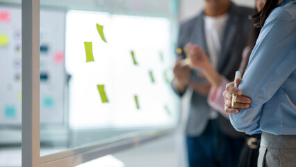 Obraz premium They are looking at the board and discussing the ideas written on the notes