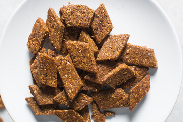 Overhead view of groundnut cake on a white plate, top view of nkatie cake or peanut cake on a plate, candy bar made with roasted peanuts and sugar