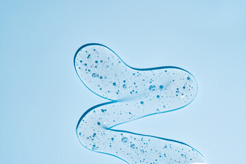 Cosmetic cream transparent or alcohol gel serum texture with micro bubble on blue background. skincare concept