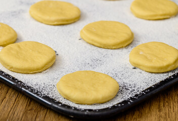 Ciasto drożdżowe na pączki rośnie na blaszce do pieczenia