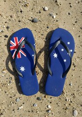 Naklejka premium Australian Flag Flip Flops on Sandy Beach with Colorful Pebbles Created with Generative AI
