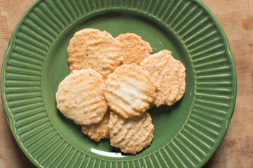 Overhead view of gurundi chips on a green plate, top view of nigerian coconut biscuits, Nigerian coconut cookies made with coconut and cassava