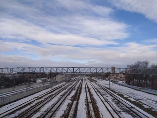 Obraz premium Railway tracks in winter with blue sky and white clouds. Russia