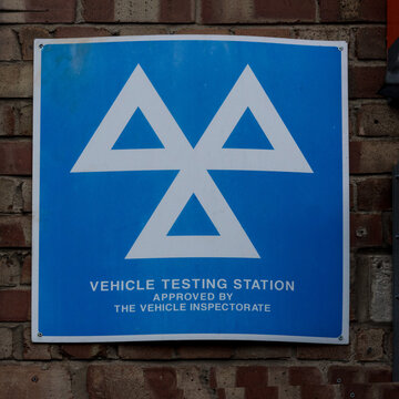 Three triangles MOT logo and sign displayed by garages approved to carry out the compulsory annual test of vehicles for road worthiness and exhaust emissions 