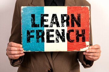 Learn French. French flag in the hands of a business woman