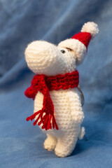 A soft toy, hand-knitted, little animal in a New Year's red cap.