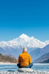 Man in Orange Jacket by Himalayan River with Snow-Capped Mountain Views