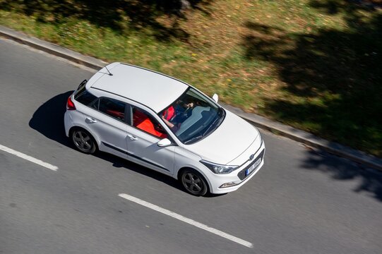 Top view of white Hyundai i20 II GB hatchback car, motion blur effect