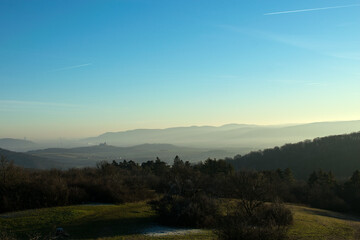 Aerial View over Hills with a Castle in the Background during Sunset