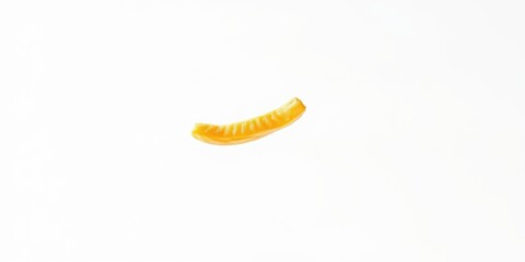 Naklejka premium A single, vibrant yellow fruit slice floats against a stark white background, showcasing its juicy texture and bright color.