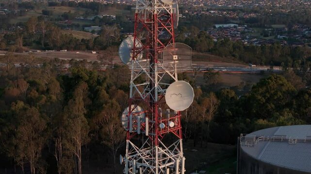 Aerial drone close up view slowly rising up above a tall mobile telecommunication cell tower on a countryside landscape background at Cecil Hills in Western Sydney, NSW Australia 